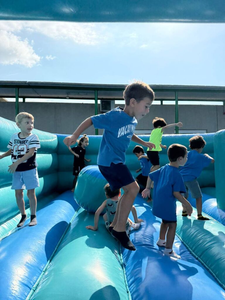 Niños jugando y saltando en un hinchable azul